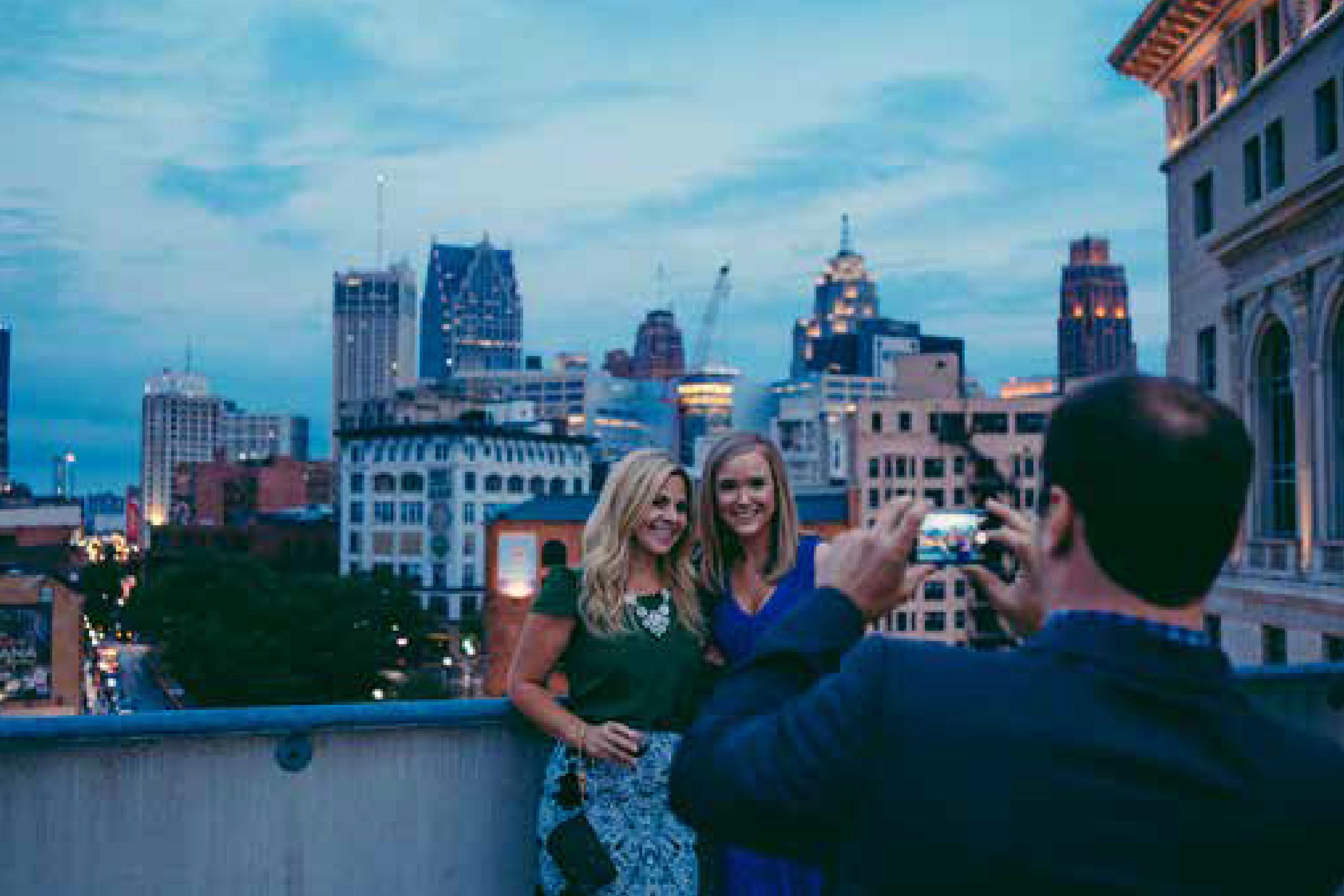 Members taking photos during a rooftop event.
