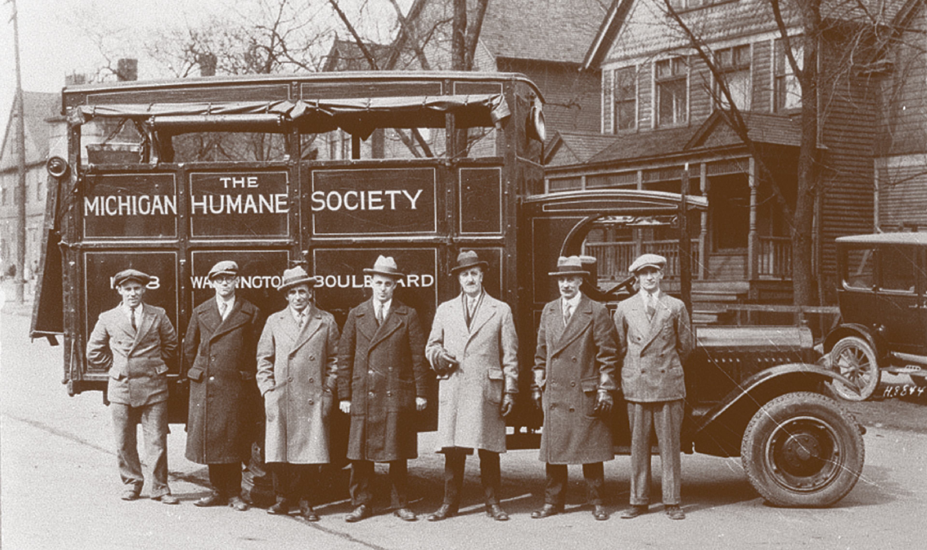 A historic sepia tone photo of the Michigan Humane early staff and their truck.